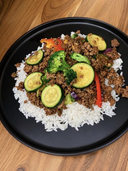Mongolian beef bowl with ground beef, broccoli, zucchini, red pepper, and rice