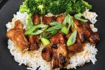 Hot honey chicken thighs coated in sweet and spicy sriracha glaze, served with rice and broccoli. Copy alt text